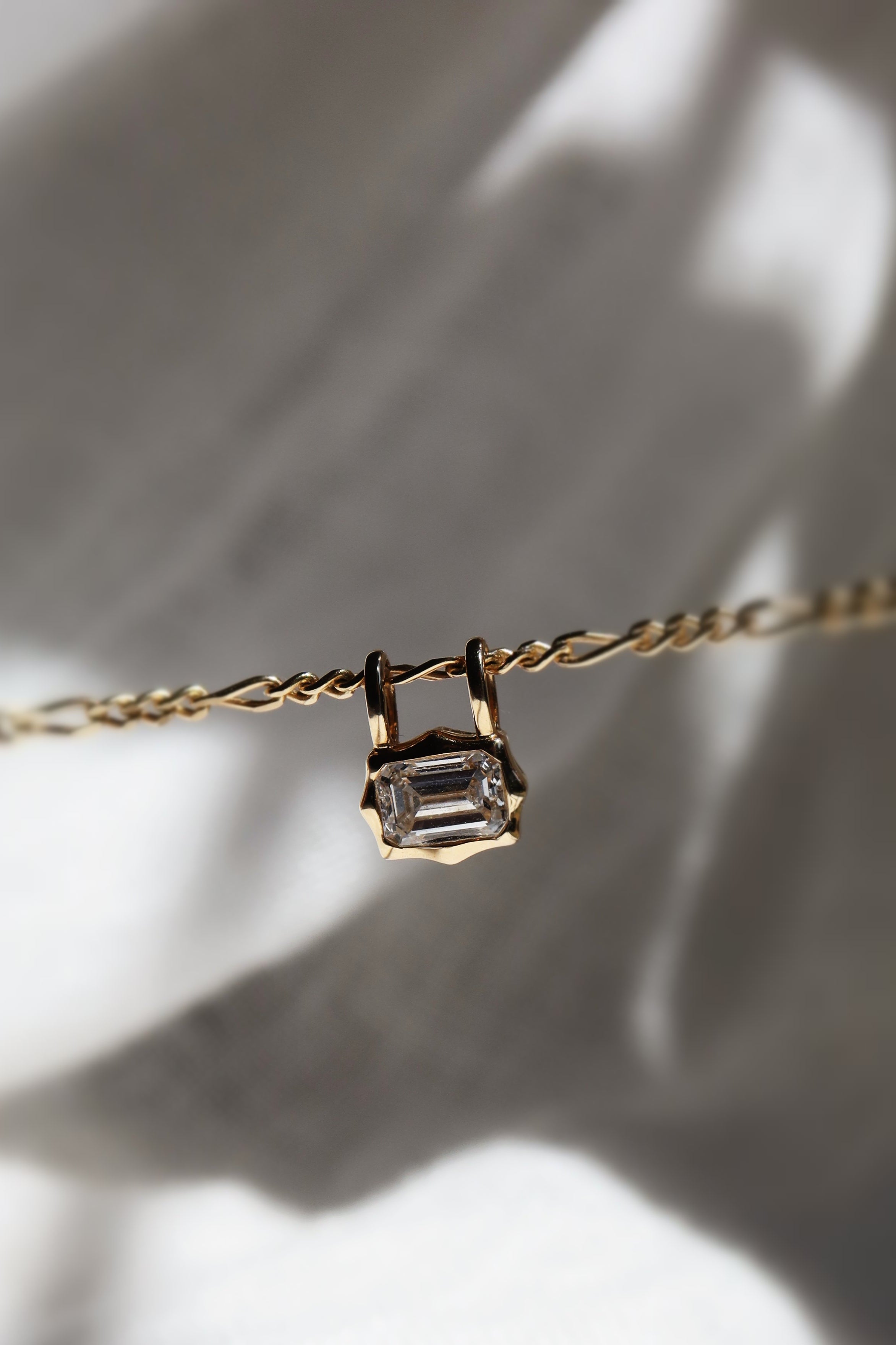 emerald cut diamond bezel pendant with double loop