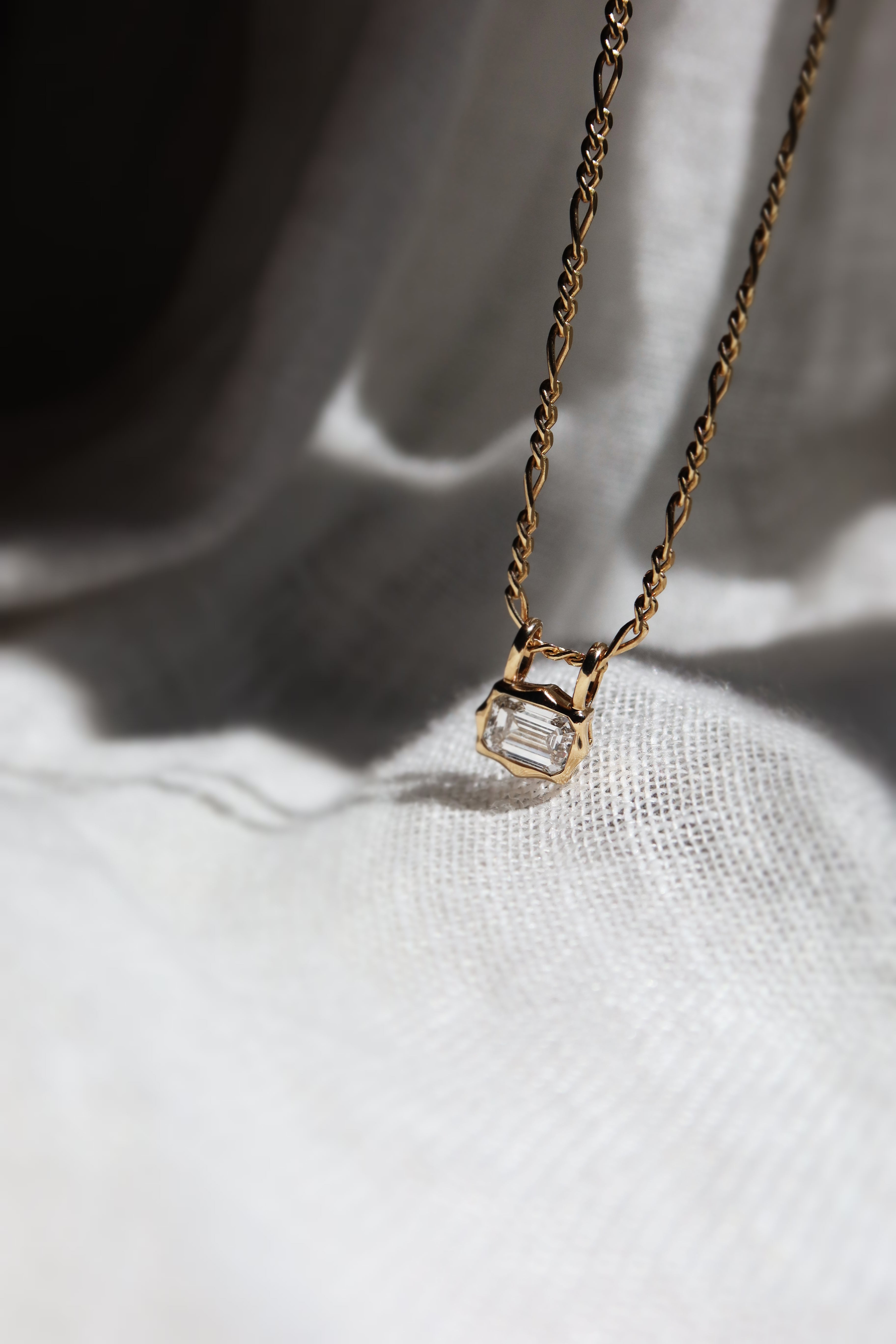 emerald cut diamond bezel pendant with double loop