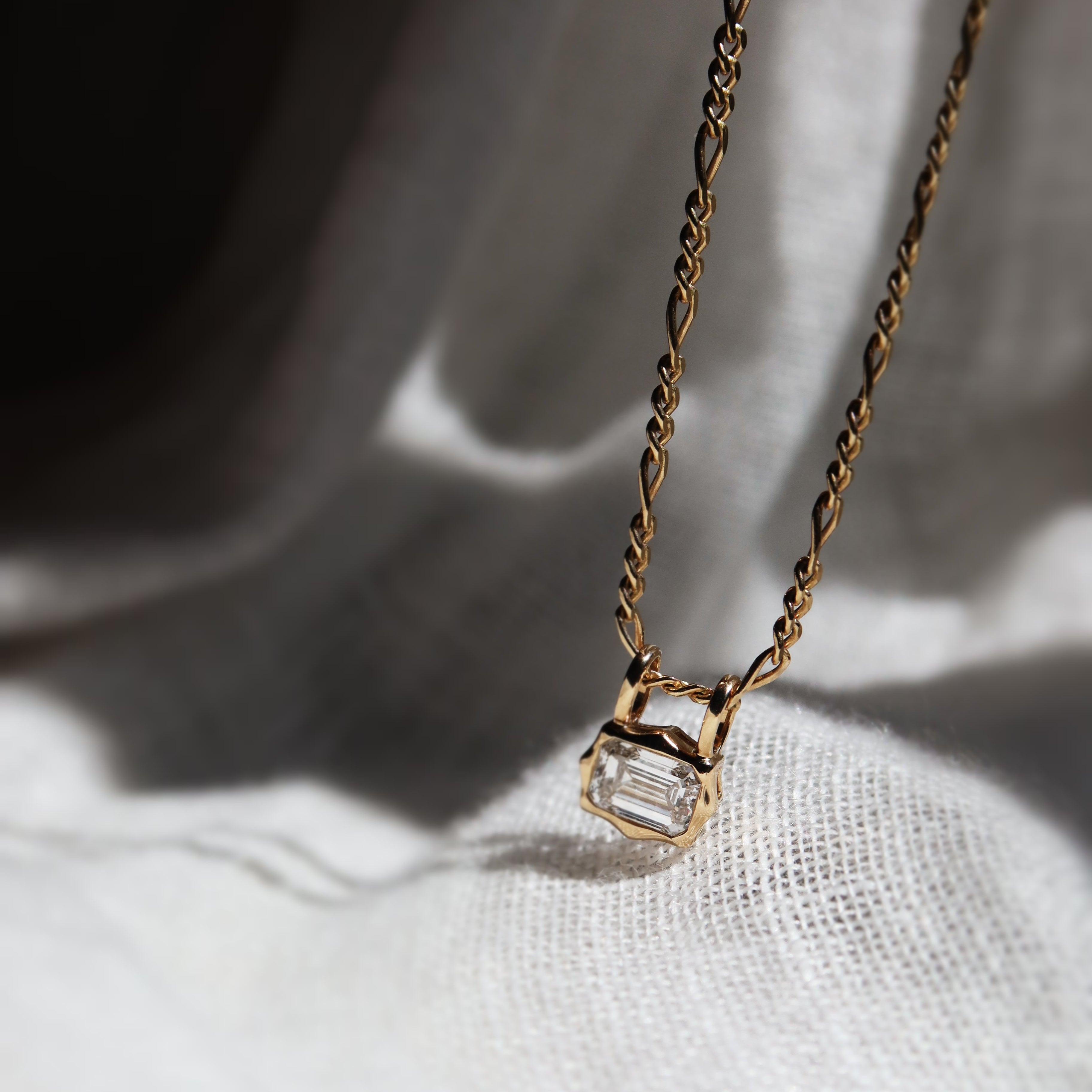 emerald cut diamond bezel pendant with double loop