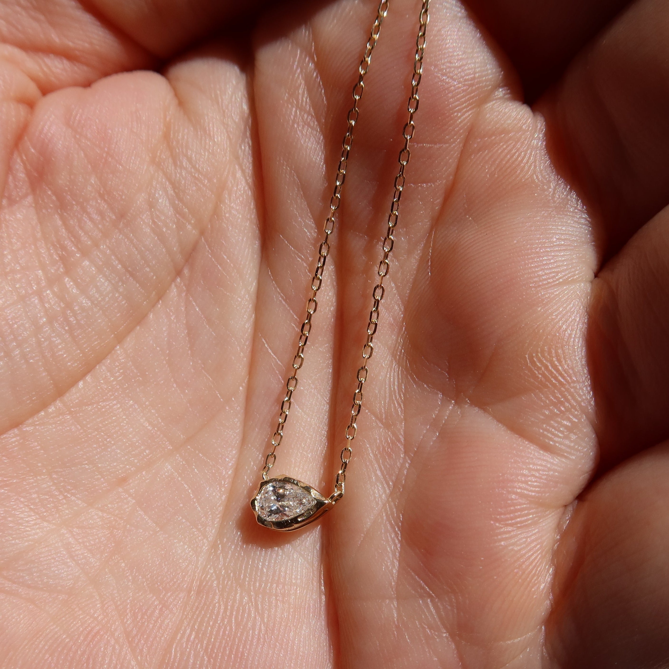 melted pear diamond bezel necklace in 10 karat yellow gold
