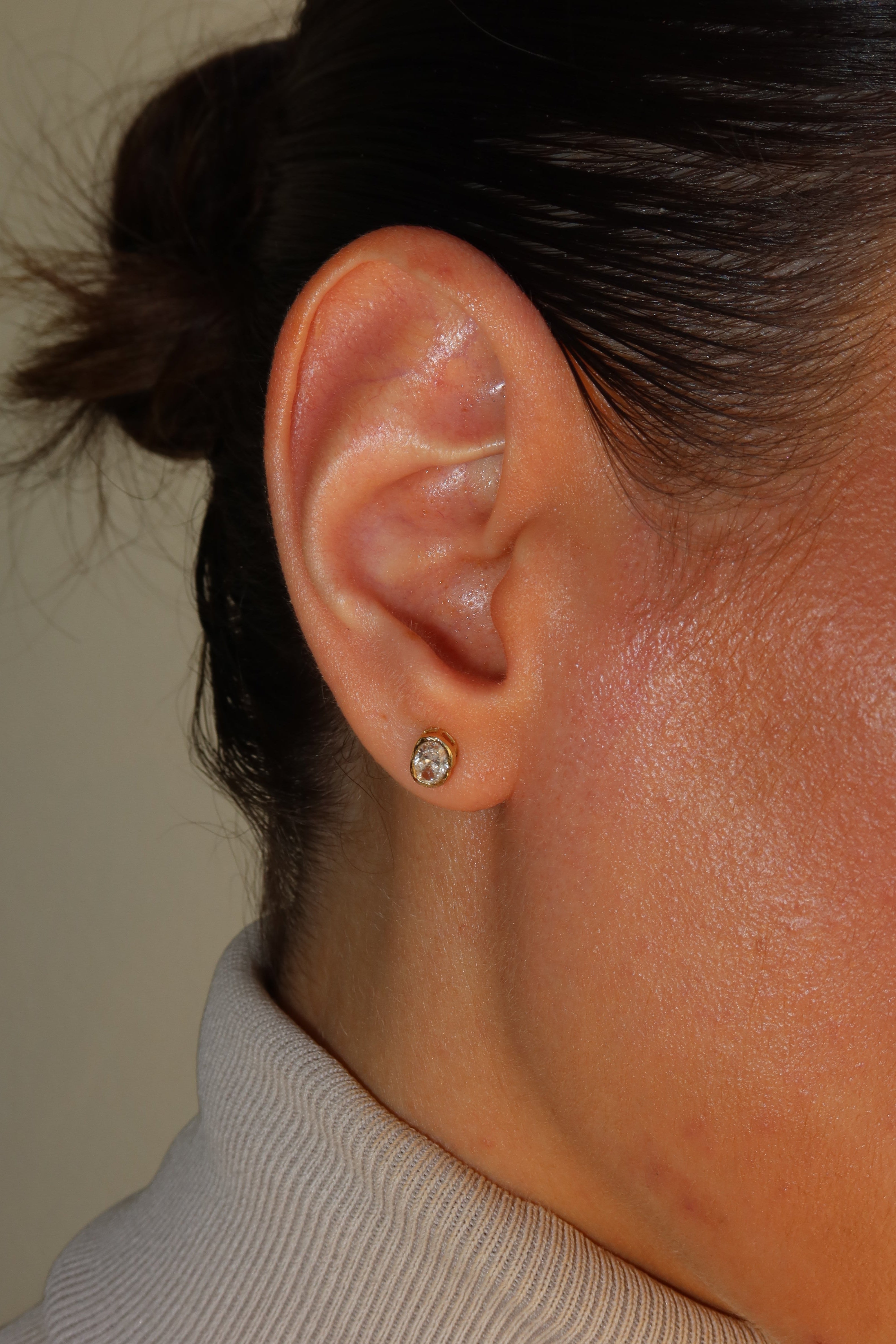 melted oval lab diamond stud earrings in 10 karat yellow gold on a female